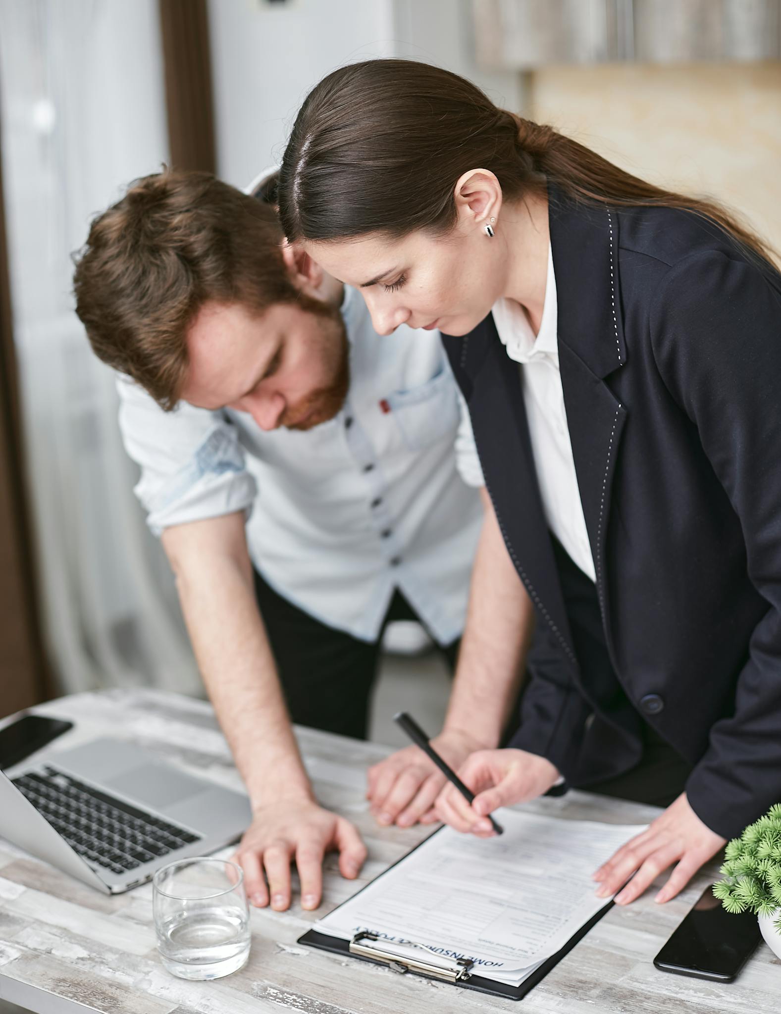 Two professionals reviewing documents together in a business setting.